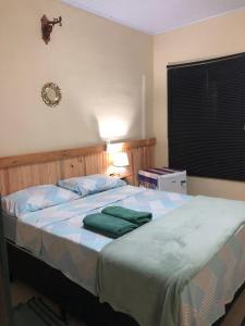 ein Schlafzimmer mit einem Bett mit zwei grünen Handtüchern darauf in der Unterkunft Pousada Casa Ferreira in Pirenópolis