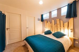 een slaapkamer met een groot bed met blauwe lakens bij groupe arbane-chardonnay in Buchères
