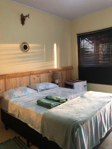 a bedroom with a large bed with a window at Pousada Casa Ferreira in Pirenópolis