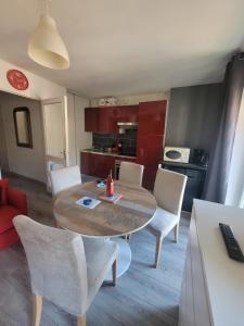 cocina y comedor con mesa y sillas en Appartement Résidence les Acacias en Ax-les-Thermes