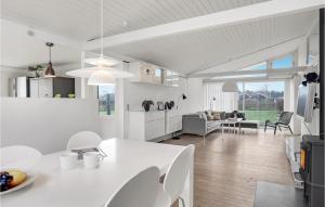 a white kitchen and living room with a table and chairs at Amazing Home In Frederikshavn With Wifi in Frederikshavn