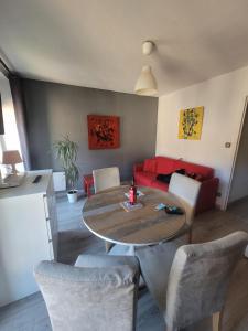 - un salon avec une table et un canapé rouge dans l'établissement Appartement Résidence les Acacias, à Ax-les-Thermes