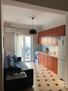 uma sala de estar com um sofá e uma cozinha em Beachwalk apartments em Chalkida