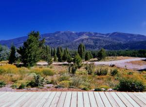 una terrazza in legno con montagne sullo sfondo di Casa Amapola a San Martín de los Andes