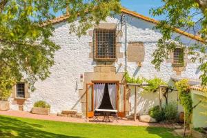 un gran edificio blanco con ventana y porche en Masia 1612 Muy cerca de las playas Costa Brava, en Calonge