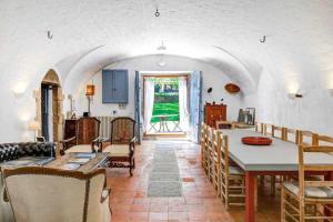 cocina y sala de estar con mesa y sillas en Masia 1612 Muy cerca de las playas Costa Brava, en Calonge