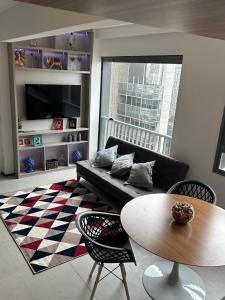 Apto Novo é confortável em Perdizes, ao lado do Allianz Park, cama king size في ساو باولو: غرفة معيشة مع أريكة وطاولة