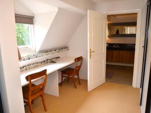 cocina con mesa, sillas y ventana en Duinappartementen Schoorl, en Schoorl