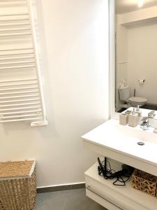 La salle de bains est pourvue d'un lavabo et d'un miroir. dans l'établissement Le Bali Cosy House - T2 lumineux et moderne en plein centre ville de Maisons-Alfort, à Maisons-Alfort