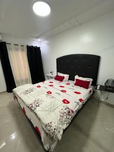 a bedroom with a large bed with red pillows at Room in Apartment - Grande Chambre Avec Toilette Integrees in Dakar