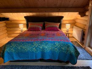 een bed in een blokhut met twee lampen bij Hahnenkleer Hütte Harzliebe in Goslar