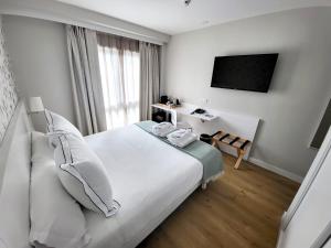 a hotel room with a bed and a flat screen tv at Hotel Monte Rozas in Las Rozas de Madrid