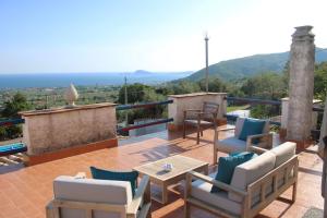 een terras met stoelen en een tafel bij Villa Bice with sea viewpool in Castellonorato