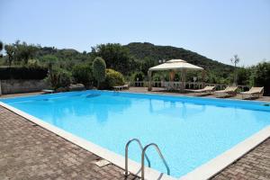 een groot blauw zwembad met een prieel bij Villa Bice with sea viewpool in Castellonorato