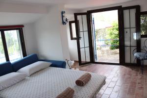 een woonkamer met een blauwe bank en glazen schuifdeuren bij Villa Bice with sea viewpool in Castellonorato