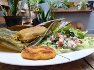 une assiette de nourriture avec une salade et un sandwich dans l'établissement Serrania Hostal, à Medellín