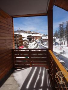 a bench on a balcony with a view of a snow covered city at Adonis Valberg in Valberg