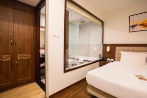 - une chambre avec un lit et un grand miroir dans l'établissement Western Hanoi Boutique Hotel, à Hanoï