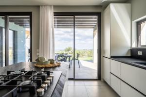 uma cozinha com um fogão e vista para um pátio em Villa vista mare Piscina e SPA em Castellammare del Golfo