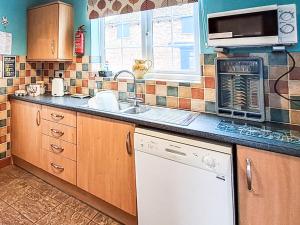 a kitchen with a sink and a stove top oven at Foston Grange Cottage in Bulmer