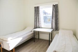 a small room with two beds and a window at Hostel Oslofjord in Stabekk
