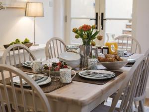 a dining room table with food and flowers on it at Sage Cottage in Blockley