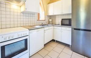 a kitchen with white cabinets and a stainless steel refrigerator at Amazing Home In Bonneville-La-Louvet in Bonneville-la-Louvet