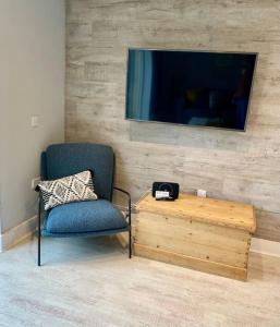 a room with a chair and a table and a tv at Sailors Snug in Beadnell