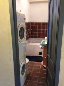 a bathroom with a washing machine next to a bath tub at Holiday home in Zalaistvand 27940 in ZalaistvÃ¡nd