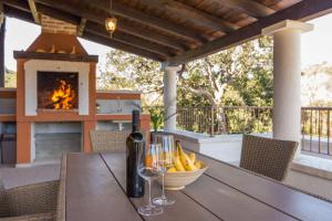 a table with a glass of wine and a bowl of bananas at Holiday Home Irena-Adriatic Luxury Villas in Žman