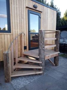 una escalera de madera que conduce a un edificio con puerta en Tiny House Calido, en Apelern