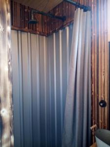 a bathroom with blue and white striped walls and a curtain at Tiny House Calido in Apelern