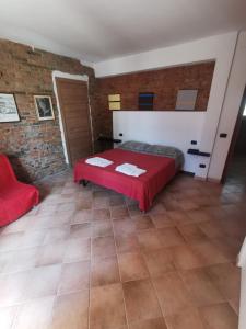 - une chambre avec un lit rouge et un mur en briques dans l'établissement FONDO MARSIGLIA 110, à Lido di Spina