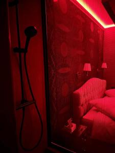 Zimmer mit einem roten Zimmer mit einem Stuhl und einer Lampe in der Unterkunft LOVE ROOM - Luxembourg in Luxemburg (Stadt)