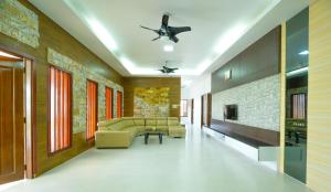 a living room with couches and a ceiling fan at Mersing Maple Villa in Mersing