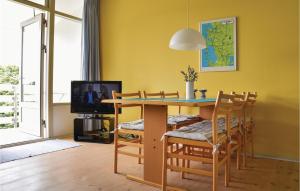 a dining room with a table and chairs and a tv at Cozy Apartment In Ringkøbing in Ringkøbing