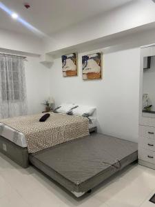 a bedroom with two beds and a dresser at 88Minesview LODGE By SUNTRUST CONDOMINIUM in Baguio