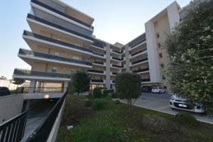 un edificio de apartamentos con un coche aparcado en un aparcamiento en Parco del Levante, en Bari