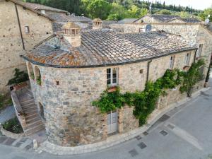 un vecchio edificio in pietra con l'edera che cresce sopra. di Antica Dimora a San Gimignano