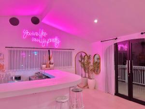 a bathroom with a pink neon sign on the wall at Pillow Inn Ubud in Ubud