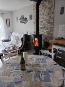 ein Wohnzimmer mit einem Tisch mit einer Flasche Wein in der Unterkunft Maison proche de l ocean in Saint-Gildas-de-Rhuys