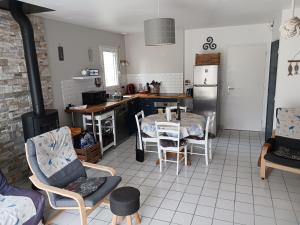 eine Küche mit Tisch und Stühlen und einem Herd in der Unterkunft Maison proche de l ocean in Saint-Gildas-de-Rhuys