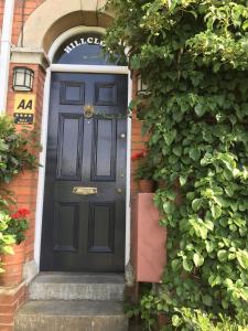 una puerta negra en el lateral de un edificio de ladrillo en The Glastonbury Townhouse B&B, en Glastonbury
