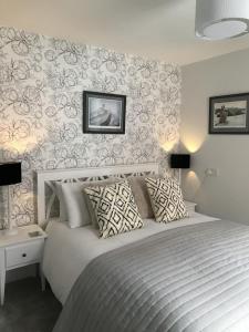 een slaapkamer met een groot wit bed met een muur bij The Glastonbury Townhouse B&B in Glastonbury