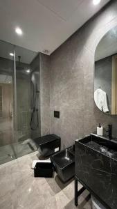 y baño con ducha acristalada y lavamanos. en Beverly Ocean Suite - By AppartAli en Casablanca