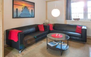 a living room with a black couch and a table at K01 Fischerkaten Haus HELENA max 5 in Dorf Körkwitz