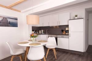 a kitchen with white cabinets and a table and chairs at K05 Fischerkaten LENI max 3 Pers in Dorf Körkwitz