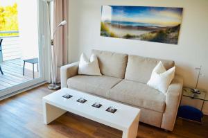 a living room with a couch and a coffee table at Buhne 10 App Nr 26 max 2 Pers in Dierhagen
