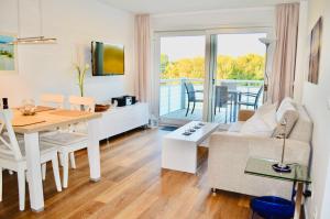 uma sala de estar com uma mesa e um sofá e uma sala de jantar em Buhne 10 App Nr 26 max 2 Pers em Dierhagen