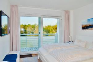 a bedroom with a bed and a large window at Buhne 10 App Nr 26 max 2 Pers in Dierhagen